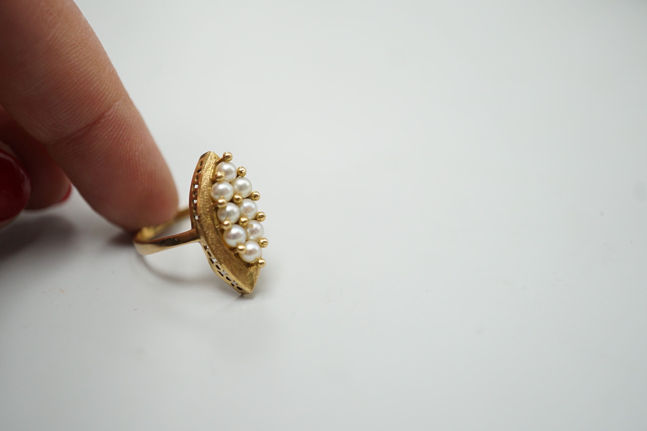 A modern continental yellow metal and seed pearl cluster set marquise shaped ring, size N